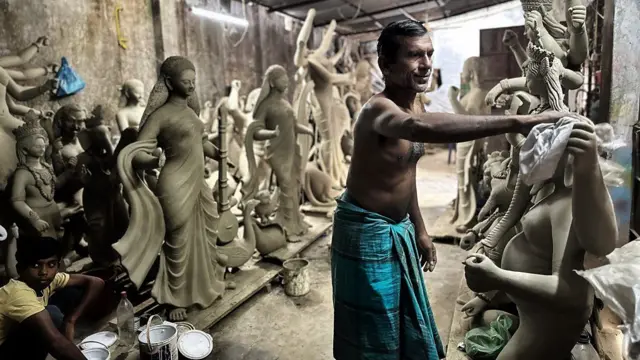 दुर्गा प्रतिमा को बनाते मूर्तिकार