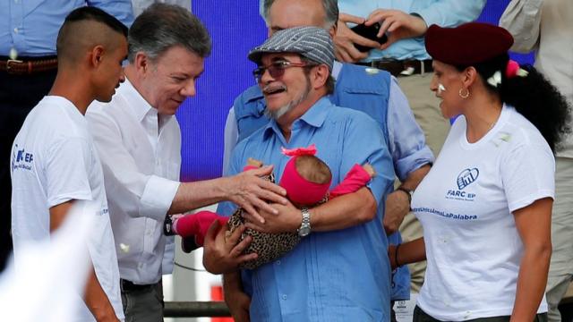 Santos y Timochenko cargan a una bebé recién nacida