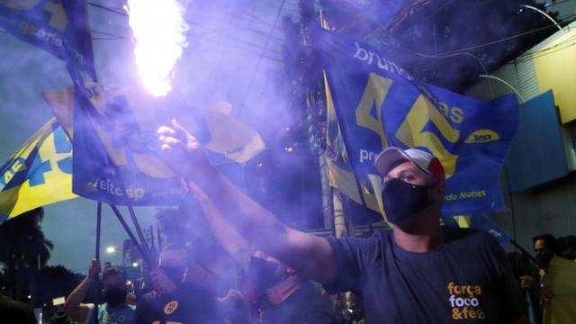 Eleitores comemoram vit[oriaesporte bet365 baixarBruno Covas com sinalizador