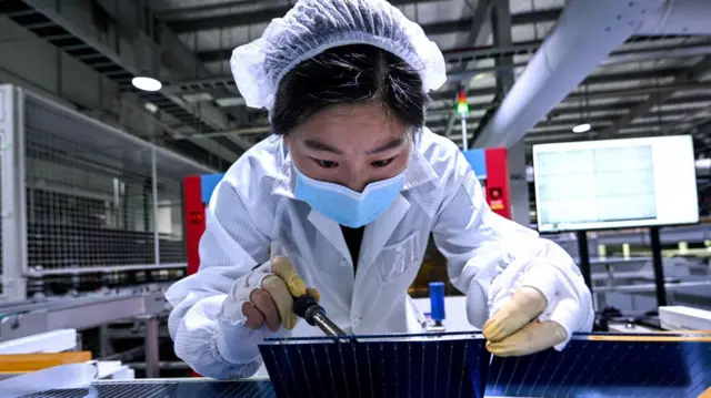 一名妇女在中国江苏省泗洪县一家工厂的太阳能板生产线上工作