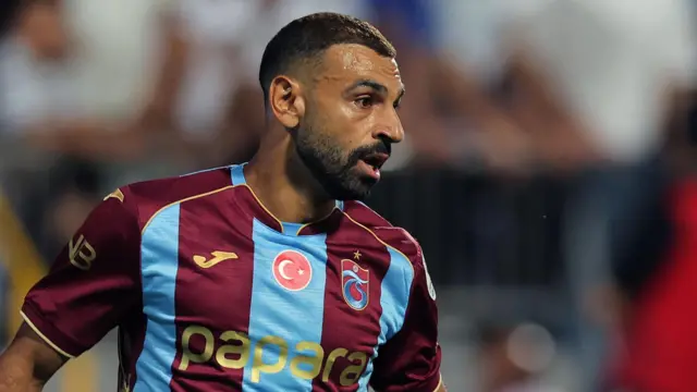 محمد صلاح بقميص نادي طرابزون سبور التركي - اللون النبيذي والأزرق مع شعار العلم التركي الدائري في الوسط