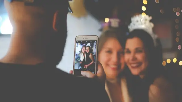 Мужчина фотографирует двух девушек