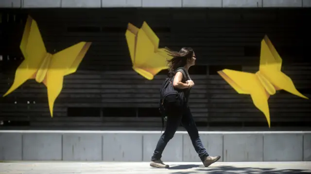 Mujer pasando frente a mariposas amarillas