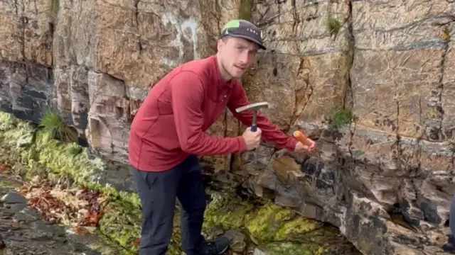 الیاس روگن کاشف آثار یخبندان در گارولاخ در این عکس با در دست داشتن یک هویج تظاهر می‌کند که میخ طلایی را صخره می‌کوبد 