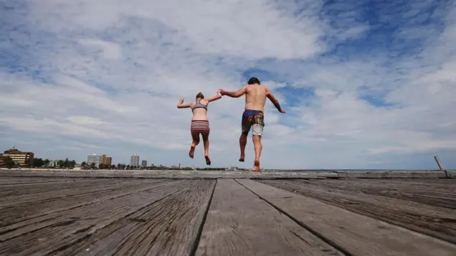 બીચ પર છલાંગ લગાવતા પિતા અને દીકરી