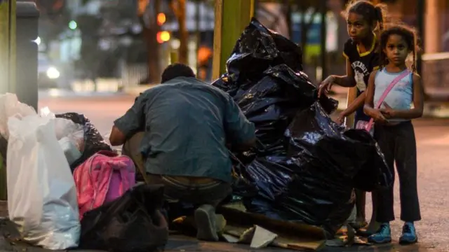 Un señor mira la basura.