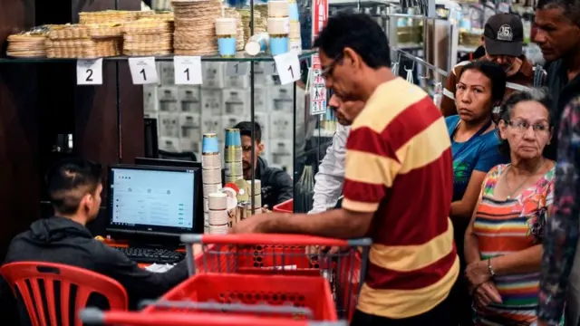 Pessoas fazem filaum caixasupermercadoCaracas