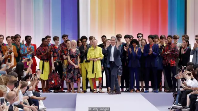 Nhà thiết kế Sir Paul Smith thư nghiệm ý tưởng com lê như hàng đồng phục và kết hợp các màu tươi hơn và cắt ngắn gọn hơn trong thiết kế của mình.