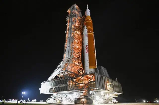 Foguete da missão Artemis 2, em visão noturna, na plataforma de lançamento