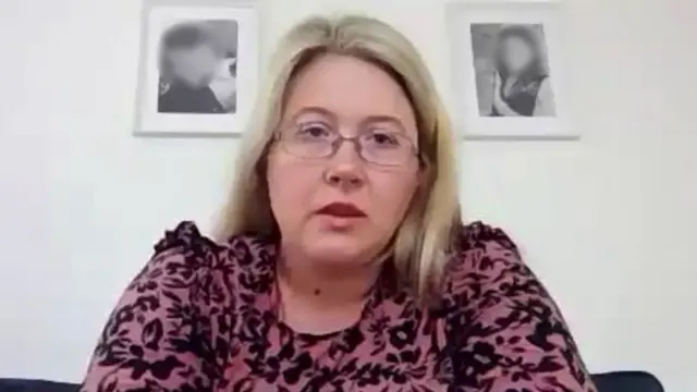 žena sa plavom kosom i naočarima gleda u kameru