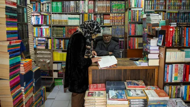 श्रीनगर के एक बुकस्टोर में एक महिला किताब पढ़ रही है.