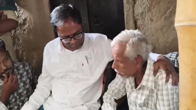 সোনালি খাতুনের বাড়িতে পশ্চিমবঙ্গ পরিযায়ী শ্রমিক কল্যাণ পর্ষদের প্রধান সামিরুল ইসলাম (সাদা জামা পরিহিত)