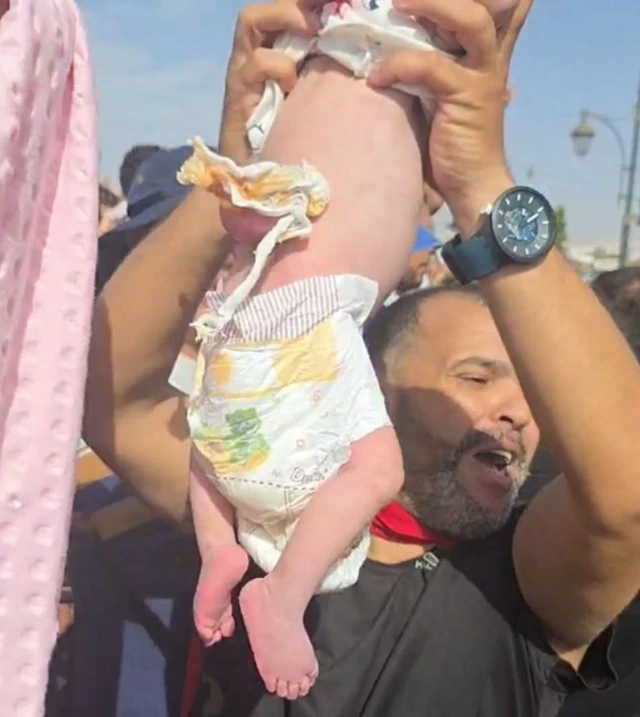 طفلة رضيعة يرفعها أحد أقربائها أثناء الاحتجاجات وقد لقيت الصورة تفاعلا واسعاً عبر وسائل التواصل