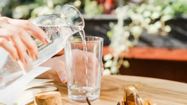 Une personne se servant de l'eau.