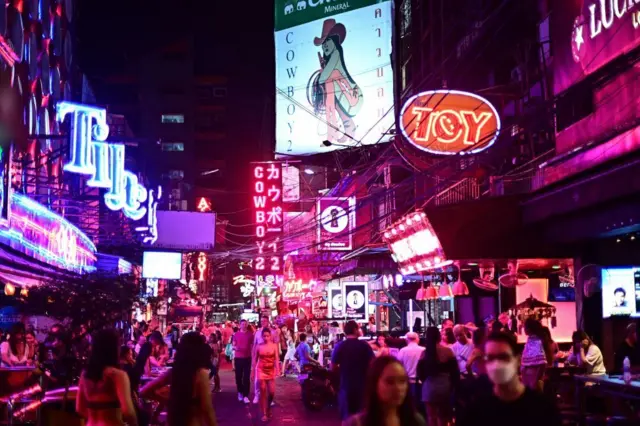 Visitors walking along the popular night entertainment street known as "Soi Cowboy" in Bangkok