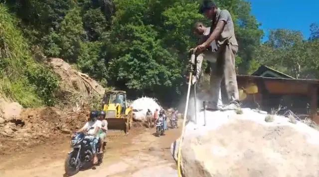 මාර්ගයට පෙරළුණු ගල් ඉවත් කරන කම්කරුවන්ගේ ඡායාරූපයකි