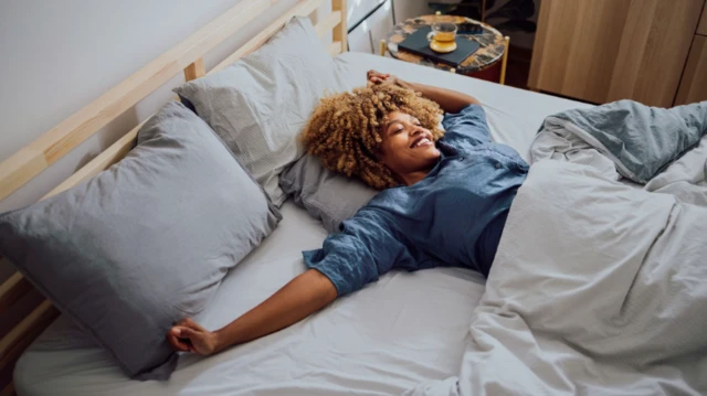 امرأة تبتسم وهي تنام وحدها في السرير