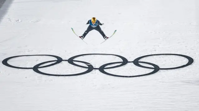 ভাল ডি ফিয়েমে অলিম্পিক রিংয়ের উপর দিয়ে লাফিয়ে উঠছেন স্লোভেনিয়ান নিকা প্রেভক