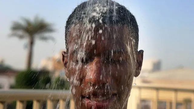 رجل كويتي يستحم ليبرد جسمه بعد السباحة في مسبح بمدينة الكويت، 29 يوليو/تموز 2015. صُنفت مدينة الكويت كواحدة من أكثر مدن العالم حرارة، حيث تتجاوز درجات الحرارة 50 درجة مئوية خلال الصيف.
