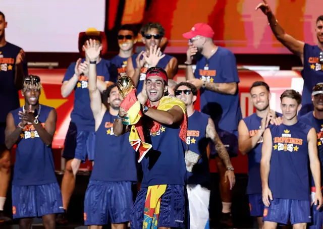 El delantero español Ferran Torres levanta la copa mientras los jugadores de España celebran en un escenario en la plaza de Cibeles de Madrid el 20 de julio de 2026, un día después de conquistar su segundo título mundial tras una victoria por 1-0 ante Argentina.
