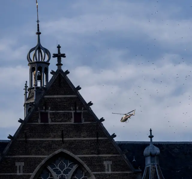 Un helicóptero sobrevuela cerca de la catedral de San Lorenzo, Rotterdam, lanzando poemas