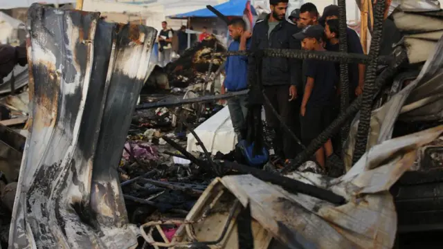 Pessoas observando escombrosjogo de futebol que paga dinheiroRafah, Gaza