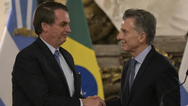 Bolsonaro e Macri apertam as mãos e sorriem, com bandeiras do Brasil e Argentina no planoaposta campeao copa do mundo 2024fundo