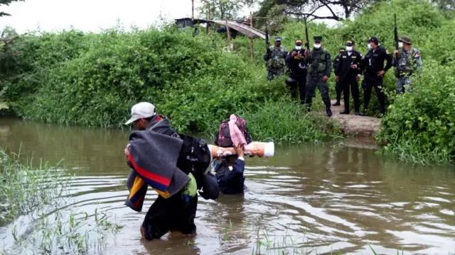 Venezolanos cruzando un río.