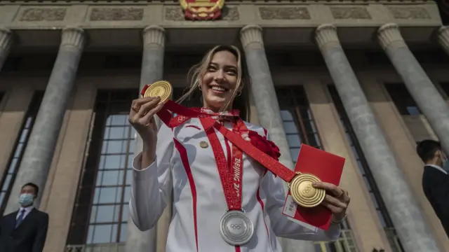 U.S. born freestyle skier Eileen Gu, or Gu Ailing, poses with her two gold medals and a silver medal before a ceremony to honour the contributions to the Beijing 2022 Winter Olympics and Paralympics at the Great Hall of the People on April 8, 2022 in Beijing, China.