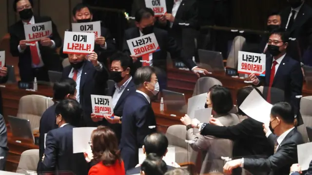 국민의힘 의원들이 28일 서울 여의도 국회에서 시정연설 마치고 퇴장하는 문재인 대통령을 향해 항의 손피켓을 들어 보이고 있다
