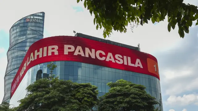 Pengendara melintas di Jalan Pejompongan Raya dengan latar belakang layar LED yang bertuliskan Peringatan Hari Lahir Pancasila di Menara BNI, Jakarta, Senin (01/06).