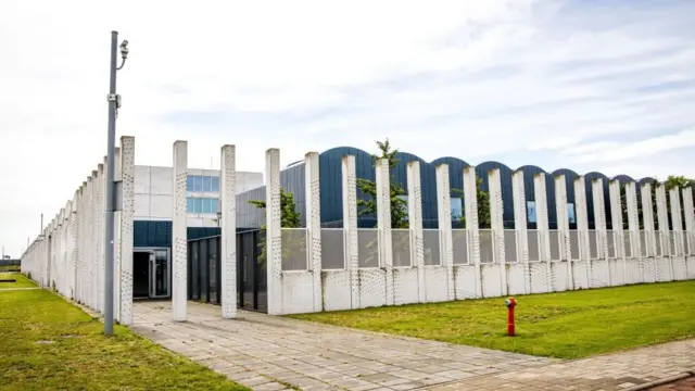 Здание-ангар за бетонным частоколом