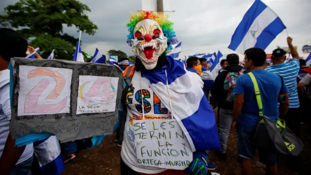 Manifestante con una máscara de payaso.