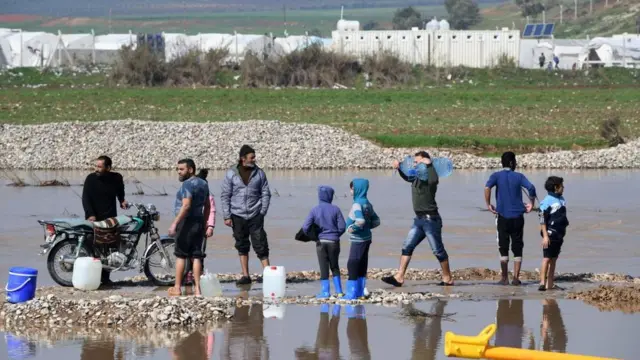 Suriyeliler şiddetli yağmurlardan sonra Afrin yakınlarındaki Deir Balut kampında temiz su bulmaya çalışıyor (11 Şubat 2019)