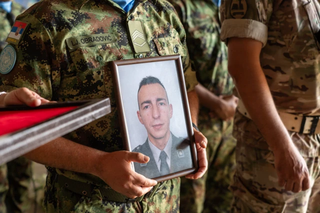 Muškarac drži fotografiju poginulog vojnika