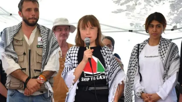 গ্রেটা থুনবার্গ (মাঝখানে) মেডলিনের ক্রুদের সাথে এক সংবাদ সম্মেলনে বক্তব্য রাখছেন