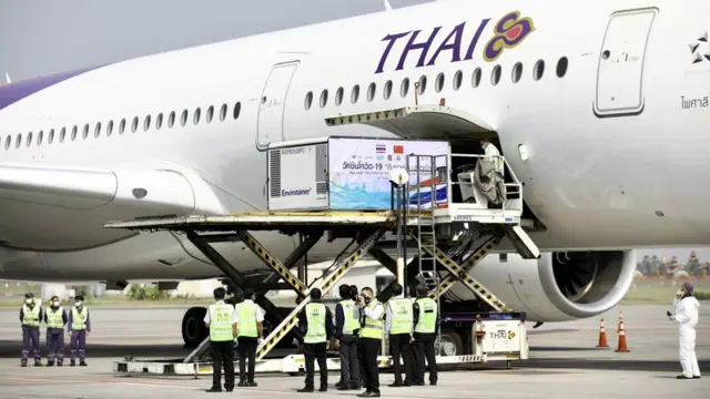 ตู้คอนเทนเนอร์บรรจุวัคซีนโควิด-19 ถูกลำเลียงออกมาจากเครื่องบินของการบินไทย