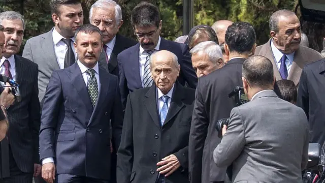 Devlet Bahçeli, çevresinde korumalar, parti yetkilileri.