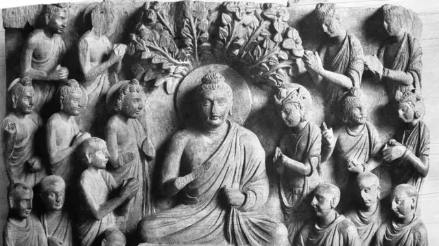 بوذا يجلس تحت شجرة بودهي ويحيط به الرهبان والأمراء والبوديساتفات، واللوحة نقش بارز من الحجارة يعود إلى القرن الثاني قبل الميلاد في المتحف الهندي بسارناث