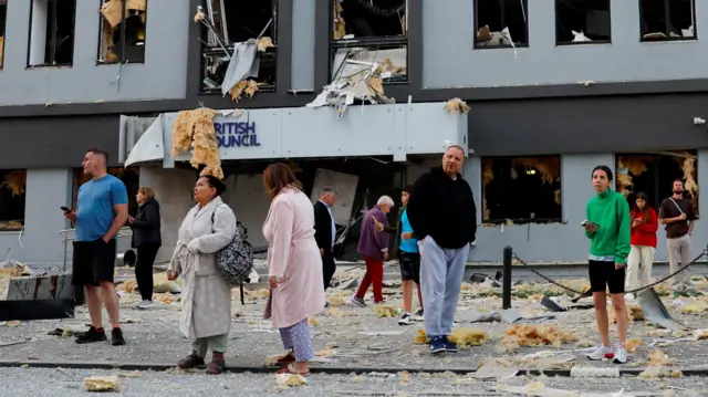 Киев, люди на фоне поврежденного здания с вывеской British Council