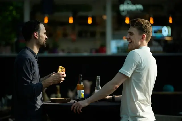 Dos hombres comiendo y charlando