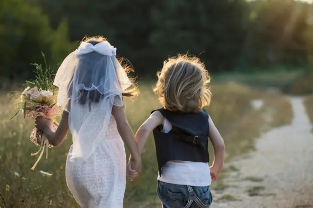 dua anak kecil berbaju pengantin sedang berlari