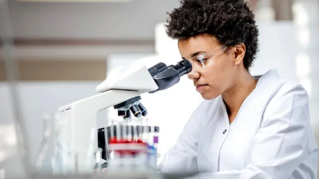 Mujer mirando por telescopio