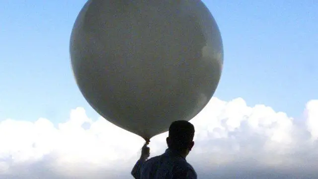 Un homme tenant un gros ballon.