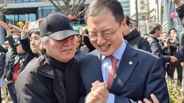 두 손을 맞잡고 기뻐하는 김상욱 의원