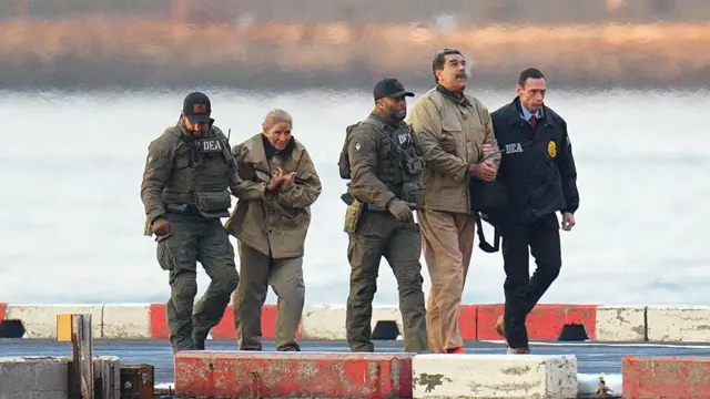Nicolás Maduro e sua esposa Cilia Flores, rodeados por policiais americanos