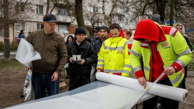 युक्रेनमा रुसी आक्रमणका कारण घरका फुटेका झ्याल ढाक्न फ्लास्टिक बाँडिँदै