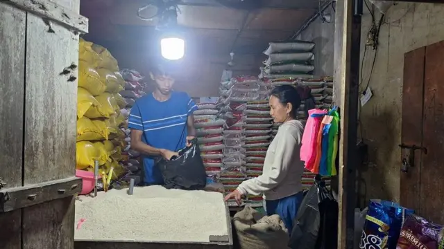Seorang warga sedang membeli beras di di pasar tradisional Toddopuli, Makassar. 