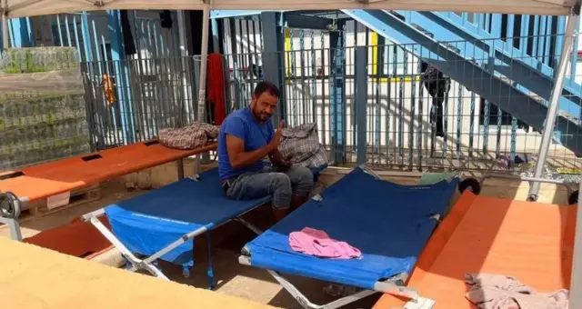 أحد المهاجرين في مخيم الاستقبال بجزيرة لامبيدوزا الإيطالية