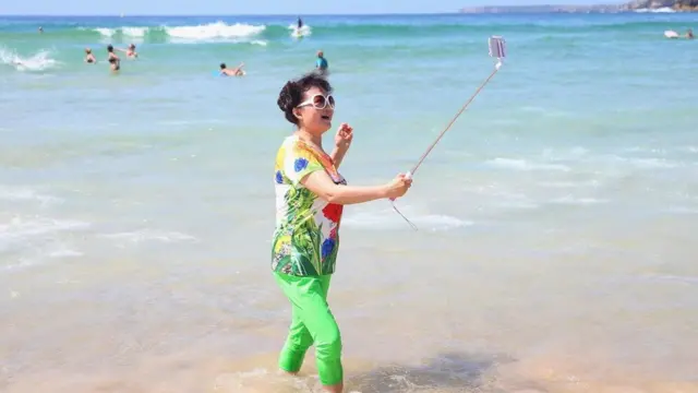 فتاة تلتقط صورة سيلفي على شاطئ البحر